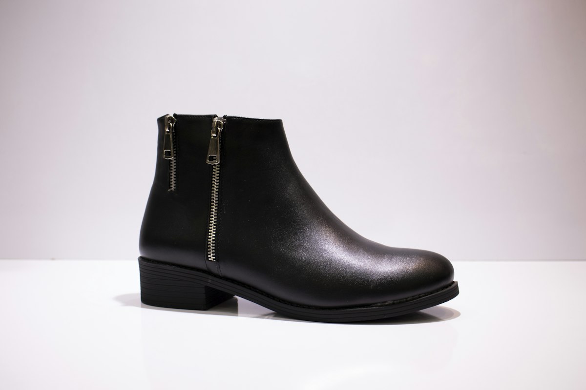 Bota de piel negra sobre una mesa blanca